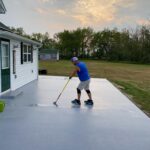 a person applying a final coating of polyaspartic coatings on a pavement